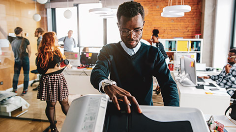 A designer retrieving printouts from the office printer