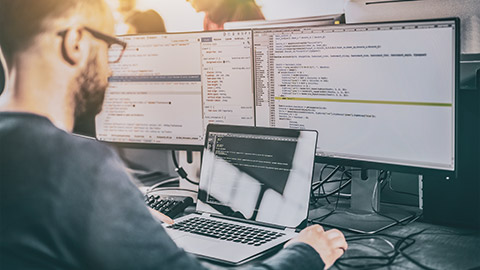 An IT person checking diagnostic information on several computers