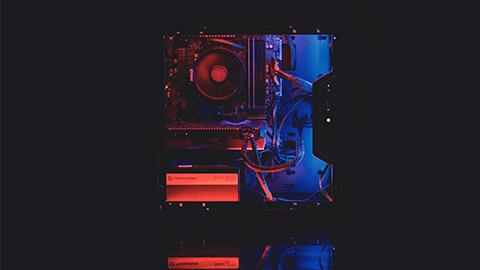 A gaming computer case illuminated with internal neon lights