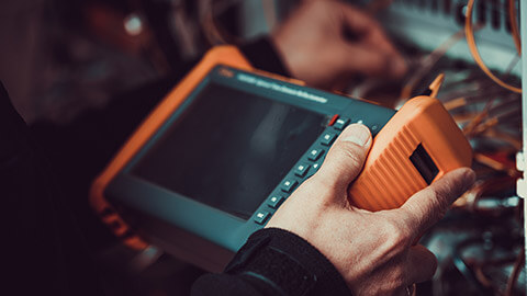 A person using a multimeter to test equipment