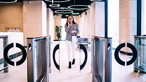 An employee leaving their modern office, through the organisation's automatic turnstile gates