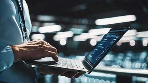 A close view of a network administrator checking details on a laptop