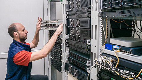 Engineer installs new switches in the server room