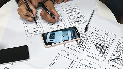 A top down view of designers working on UX wireframes