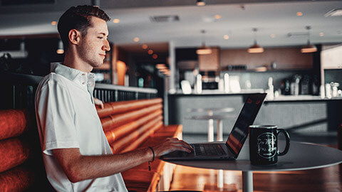 A programmer working on a project on a laptop at a table