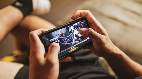 Over the shoulder view of a person gaming on a phone