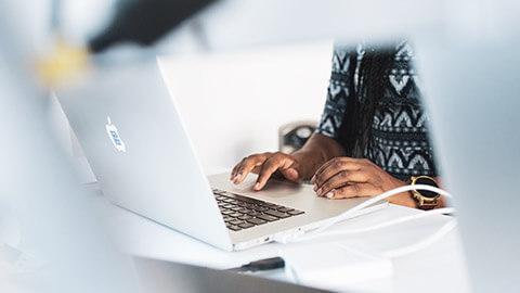 A close view of a designer working on a laptop in an office