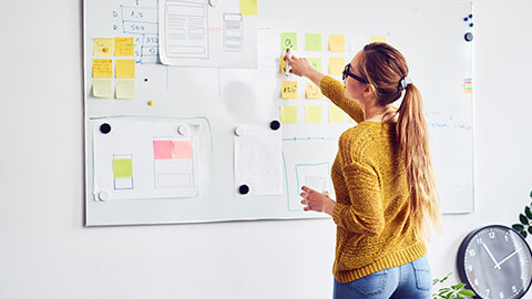 A designer mapping out a prject on a whiteboard