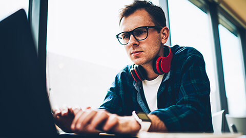 A designer concentrating on a task on a laptop