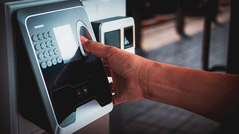 A close view of a person using a thumbprint scanner