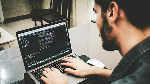 A developer working on code on a laptop