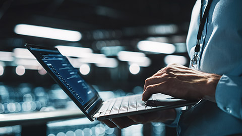 A close view of a system administrator checking IT issue on a laptop