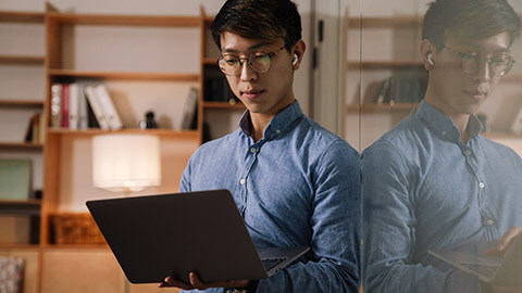 An IT professional checking something on a laptop