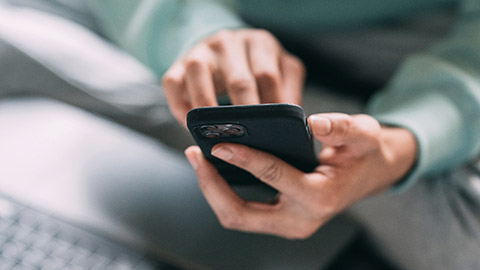 A close view of a person using a phone and computer