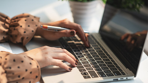 Female hands typing on the keyboard.