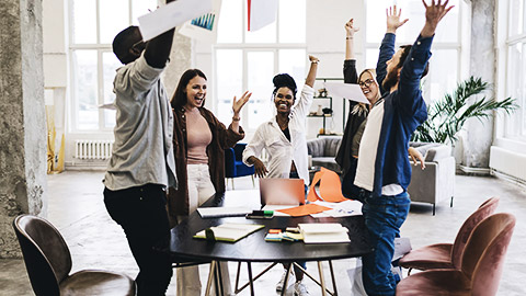 A group of people happily celebrating after closing a project