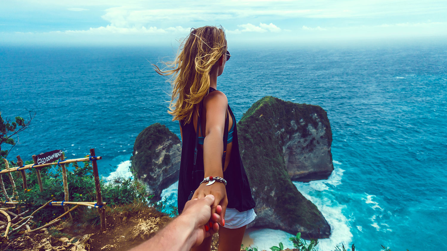 Couple follow me in island, Woman wanting her man to follow her in vacation or honeymoon to beach by the ocean, love, hair wild, Indonesia Bali