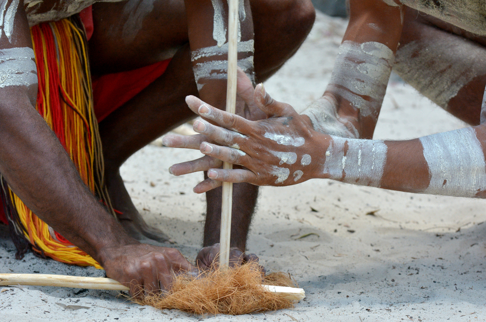 Hands of Australian Aboriginal men demonstrating fire making craft on Aboriginal Australian culture show in tropical north of  Queensland, Australia.