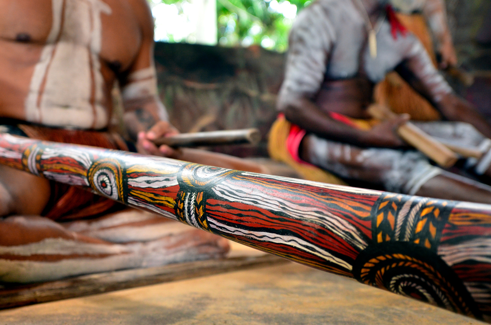 Australian Aboriginal men playing Aboriginal music on didgeridoo and wooden instrument during Aboriginal culture show