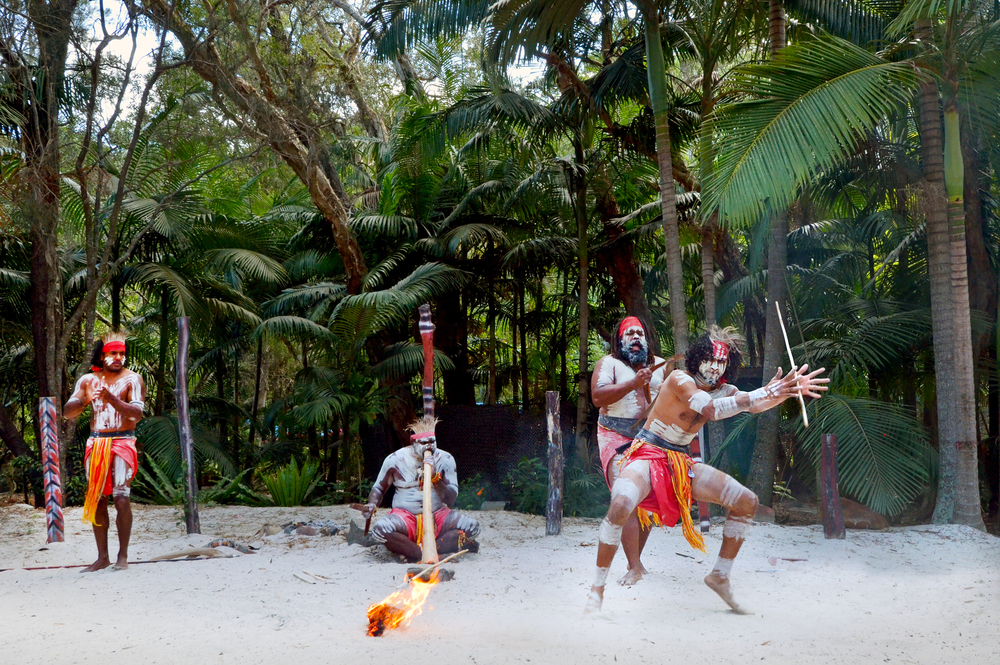 Group of Australian Aboriginal people dancing and play music of  Indigenous Australian dance during a culture show in the tropical far north of Queensland, Australia.