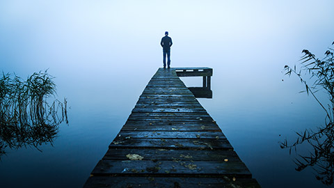 Man standing on a dock in morning fog