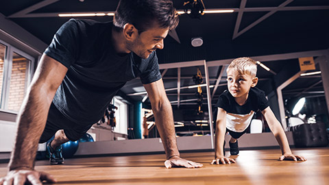 Instructor showing child how to do pushup