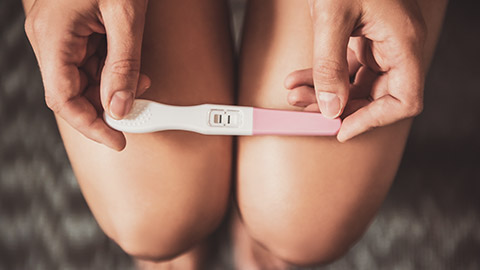 Woman holding pregnancy test