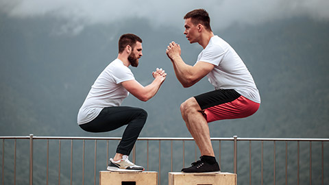 2 men balancing on boxes