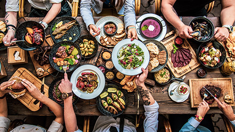 Overview of table with group sharing large amount of food