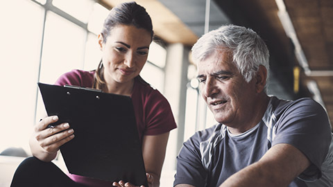 Female trainer consulting with mature male client