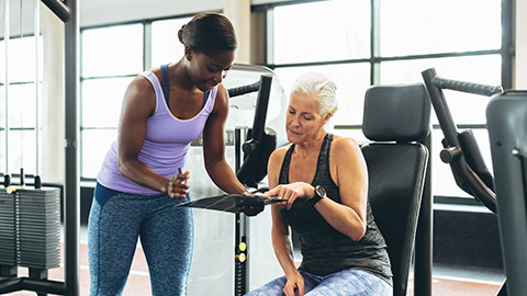 Female trainer talking to client while holding a clipboard