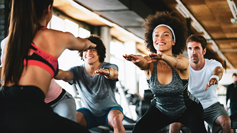 Female trainer leading energetic fitness class