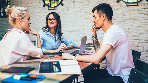 Group of young business people discussing business plan at a cafe