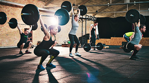 group using barbells in gym