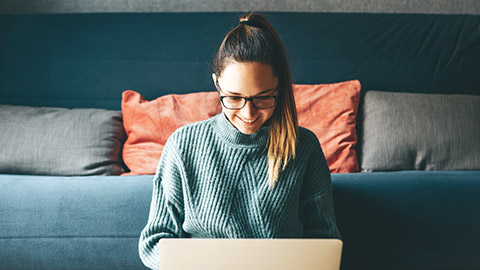 Young aspirational female working on laptop in house