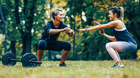 Female trainer with female client training outdoors