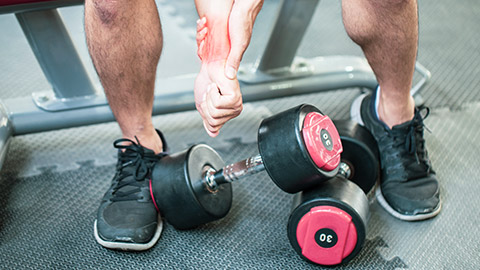 man with wrist injury dropping bumbell