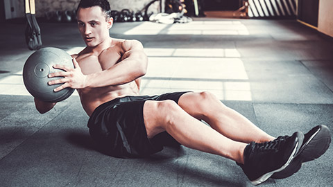 man using medicine ball on floor