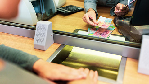 currency exchange with teller handing over currency