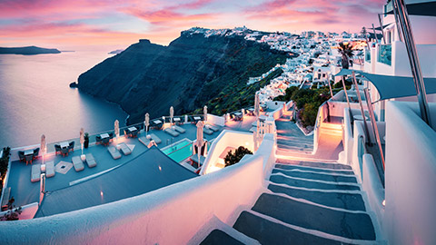 sunset over buildings in greek islands