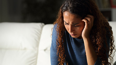 A grieving young person with their head in their hands