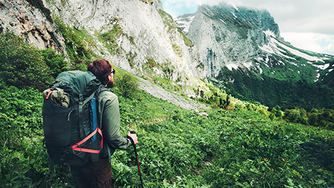 man hiking in lush green mountains