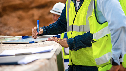 Man on worksite writing on whiteboard