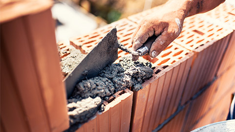 A bricklayer building walls with bricks