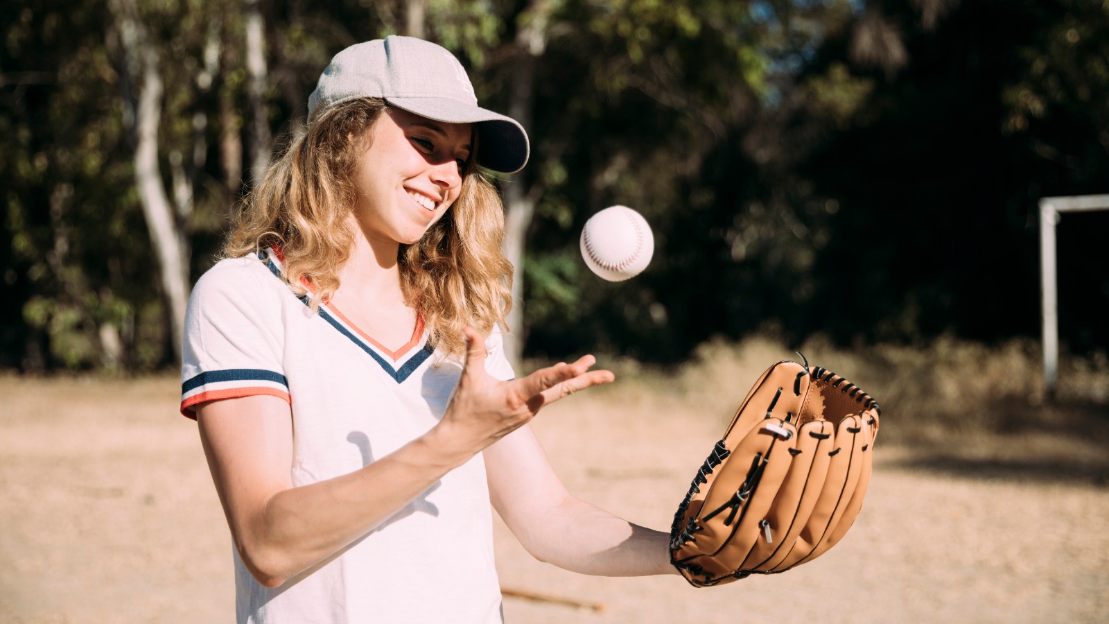 Teenage girl catching a baseball in a glove