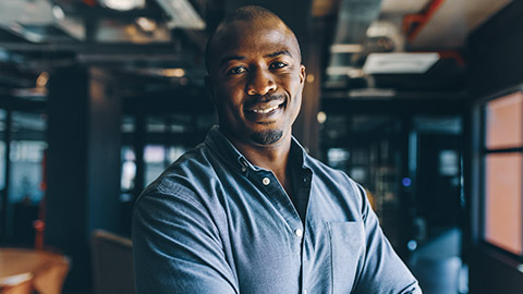 Relaxed african businessman facing the camera in a modern office