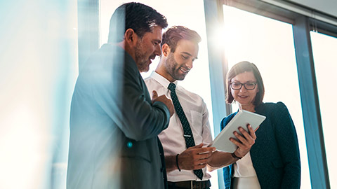 3 business colleagues viewing a piece of software on a tablet device