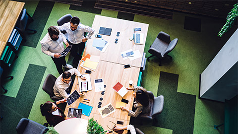 The executive team of a business holding a meeting in an open plan office