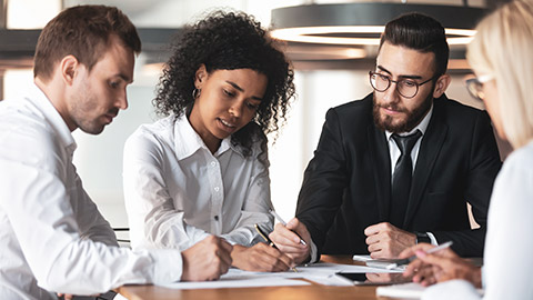 Group of business people sitting around a table negotiating