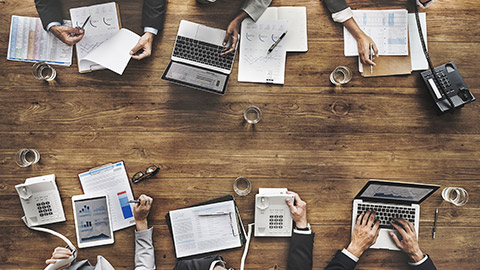 Aerial view of accounting organisation analysing financial systems at large desk